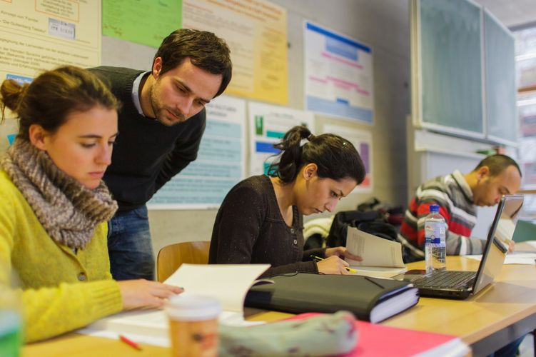 Studierende sitzen im Seminar und schauen in Bücher, Foto: Christian Hüller