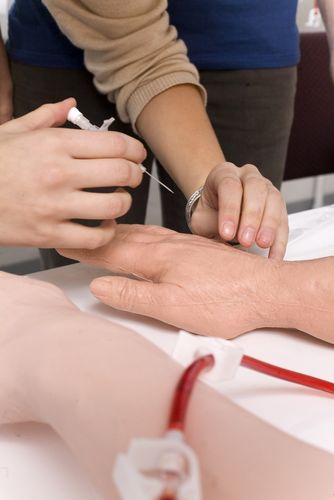 Student sticht mit einer Nadel in die Hand einer Übungspuppe, Foto: Christian Hüller