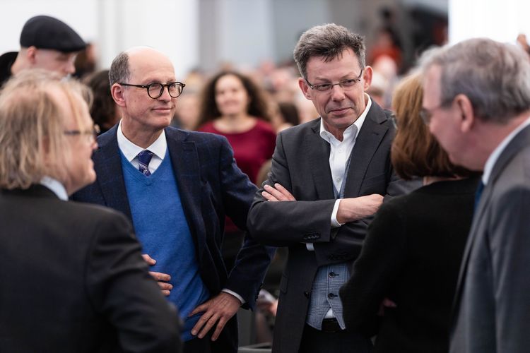 Personen stehen beim Gespräch im Kreis zusammen, Foto: Christian Hüller