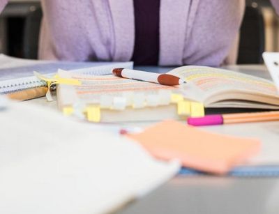 Studentin arbeitet mit Klebezetteln am Arm und stützt den Kopf auf die Hände, Foto: Christian Hüller