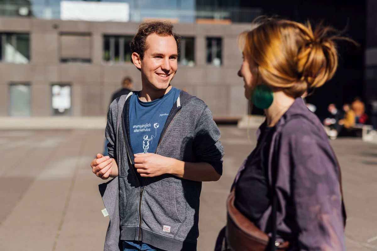 zur Vergrößerungsansicht des Bildes: Studienbotschafter Benjamin im Gespräch auf dem Campus, Foto: Christian Hüller