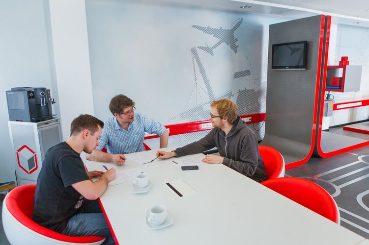 Studierende sitzen an einem großen Tisch beisammen, Foto: Christian Hüller