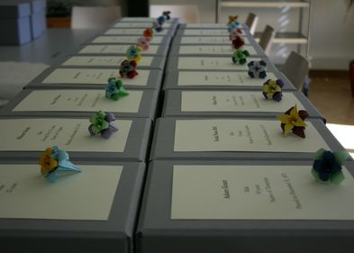 Mitarbeiter:innen des Instituts für Anatomie verpackten die Schädel behutsam in einzelne Kartons und verzierten diese für die feierliche Beisetzung. Foto: Universität Leipzig, Mandy Wagner Zu sehen sind Kartons mit verpackten Schädeln, die für die Beisetzung mit Blumen verziert wurden.