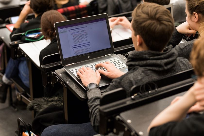 Student sitzt in der Vorlesung und hat seinen aufgeklappten Laptop vor sich, Foto: Christian Hüller