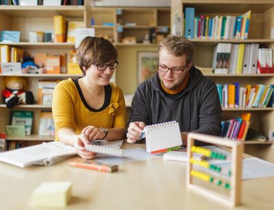 Studentin und Student sitzen in der Lernwerkstatt beisammen und schauen sich Material an, Foto: Christian Hüller