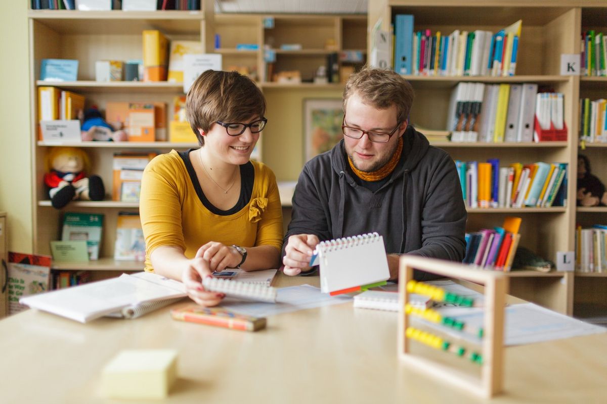 zur Vergrößerungsansicht des Bildes: Studentin und Student sitzen in der Lernwerkstatt beisammen und schauen sich Material an, Foto: Christian Hüller