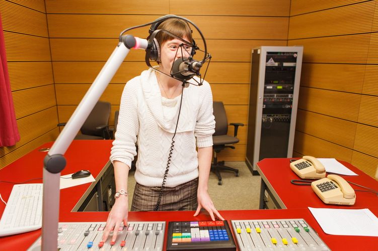 Studentin steht in einem Hörstudio und spricht ins Mikrofon, Foto: Christian Hüller 