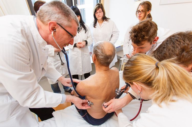 Arzt und Studierende hören einen Patienten ab, Foto: Christian Hüller 