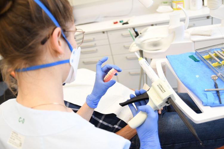Studentin mit Mundschutz bei der Abformung für eine Prothese in der Zahnklinik, Foto: Anton Stoll