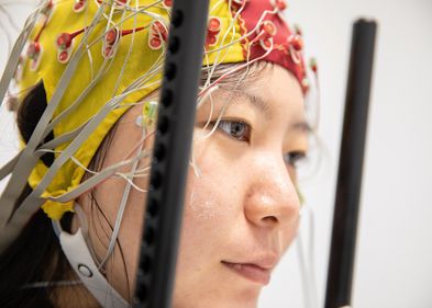 Eine Testperson mit angebrachter EEG-Haube, welche die simultane Spannungsmessung an 64 Stellen der Kopfoberfläche ermöglicht.. Eine Testperson mit angebrachter EEG-Haube, welche die simultane Spannungsmessung an 64 Stellen der Kopfoberfläche ermöglicht..