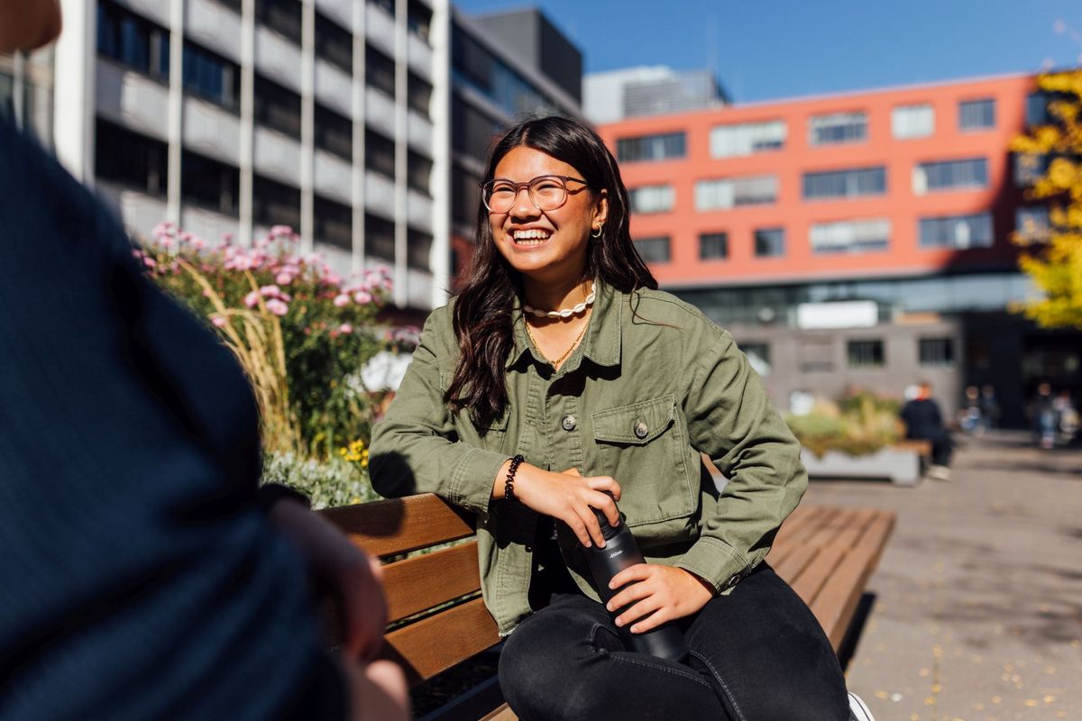 zur Vergrößerungsansicht des Bildes: Studienbotschafterin Angela lächelt auf dem Campus, die Sonne scheint, Foto: Christian Hüller