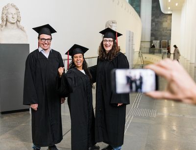 Drei Alumni werden im Neuen Augusteum mit dem Smartphone fotografiert